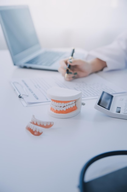 치과 의사 들 은 노트북 스크린 에 있는 스레이 이미지 를 환자 들 에게 보고 하면서 치과 문제 에 대해 논의 하고 있다