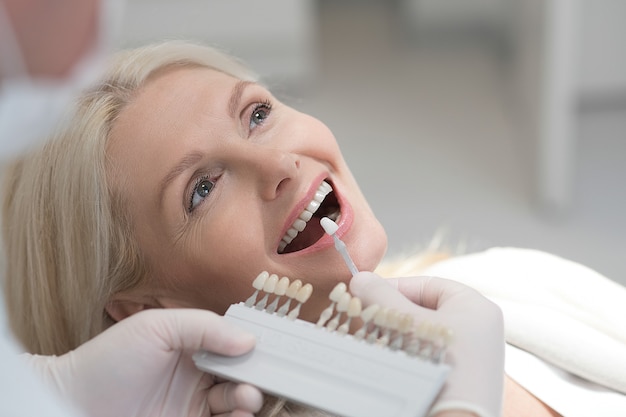 Dai dentisti. una paziente bionda che si sottopone a un trattamento dentale dai medici