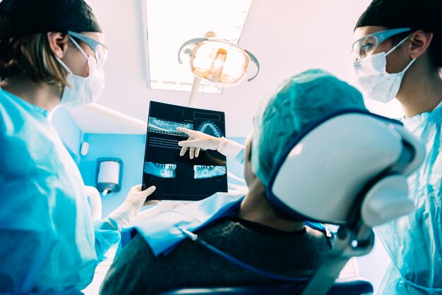 Dentists examining male patient in clinic