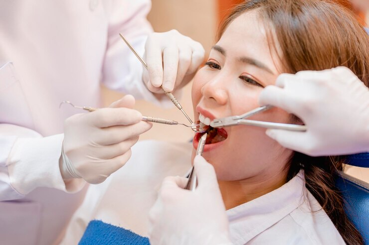 Photo 치과 의사는 클리닉에서 환자를 검사합니다.