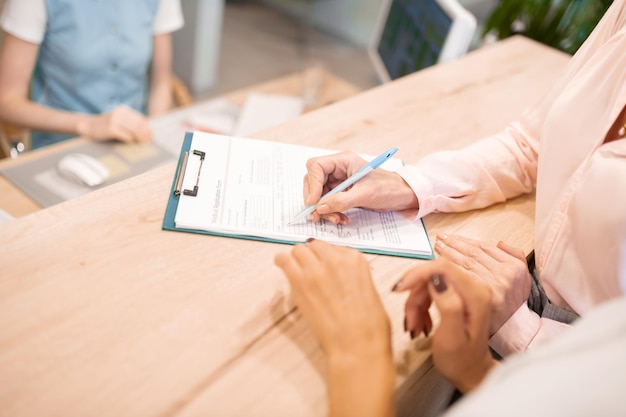 Dentists patient filling up her medical application form