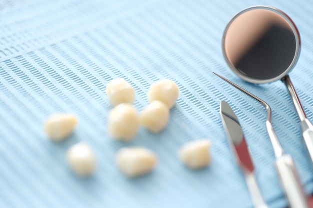 Зубные протезы и стоматологический инструмент на столе крупным планом