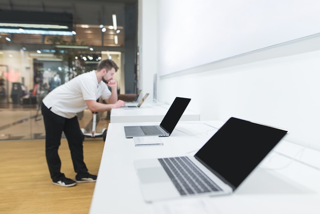 Dipartimento di computer portatili nel negozio di tecnologia. l'acquirente sceglie un laptop nel negozio di elettronica.