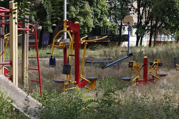 Depicted is an abandoned overgrown sports ground with various simulators for training the body and muscles