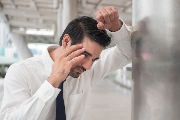 Uomo d'affari asiatico depresso; ritratto di un uomo asiatico indiano malato con depressione che soffre di mal di testa, vertigini, postumi di una sbornia, emicrania, stress