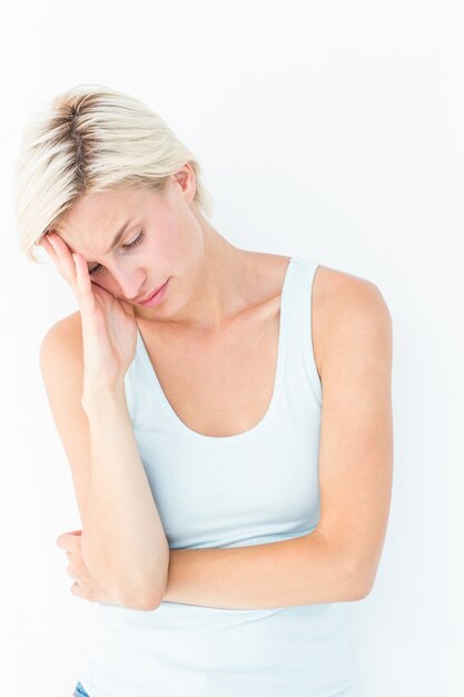 Depressed blonde woman with hand on temple 