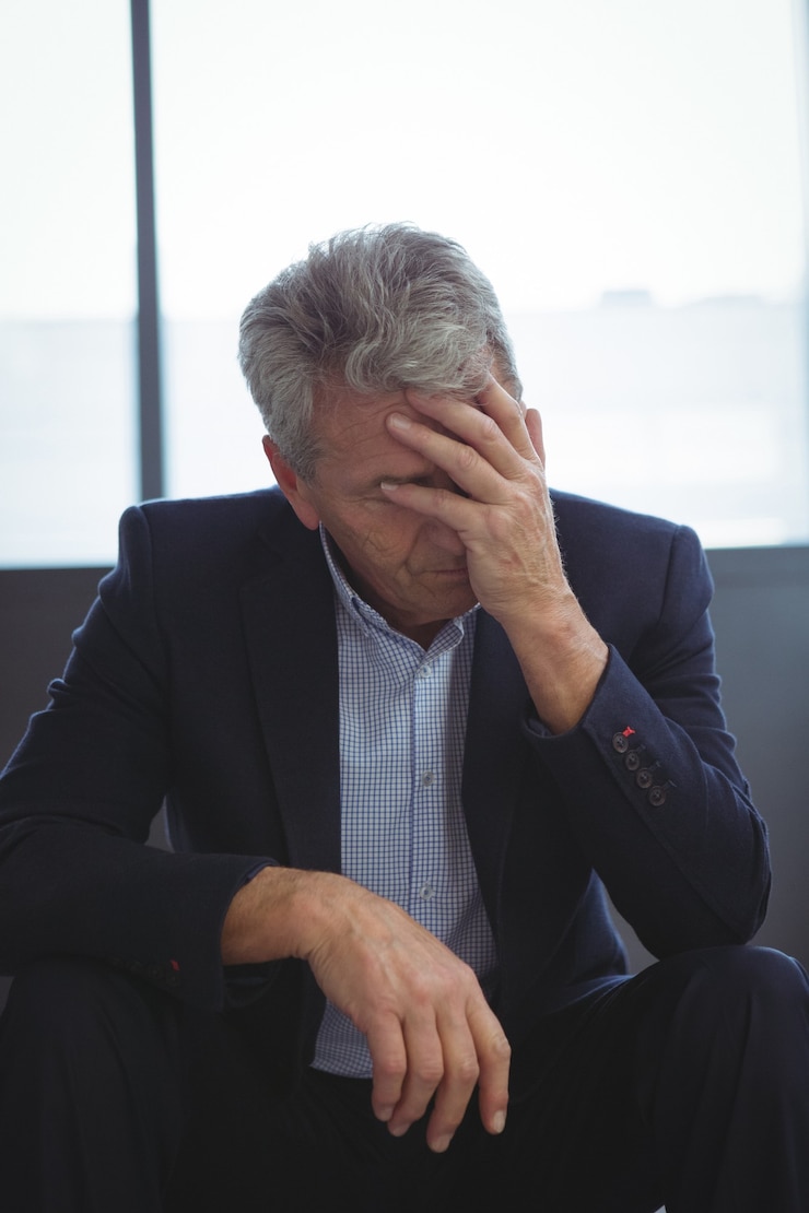 Photo depressed businessman sitting with hand on head