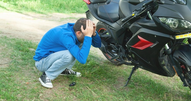 Depressed caucasian biker with a motorcycle