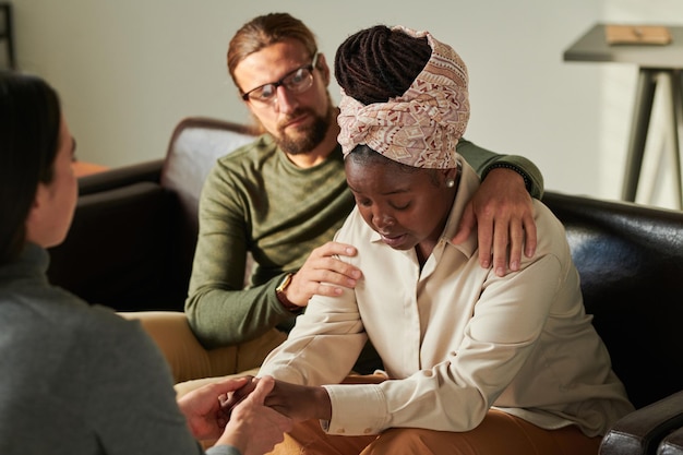 Depressed couple talking to psychologist at office