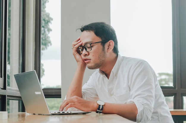 Depressed desperate businessman looking frustrated being overworked sitting at home office desk