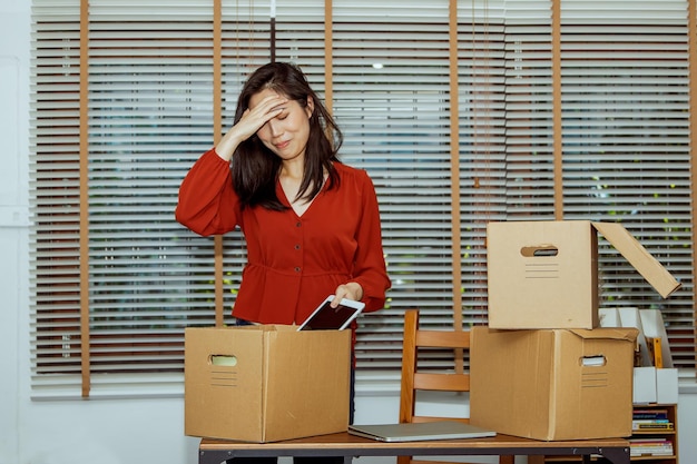 Depressed female office worker preparing to change job depressed at workstation.