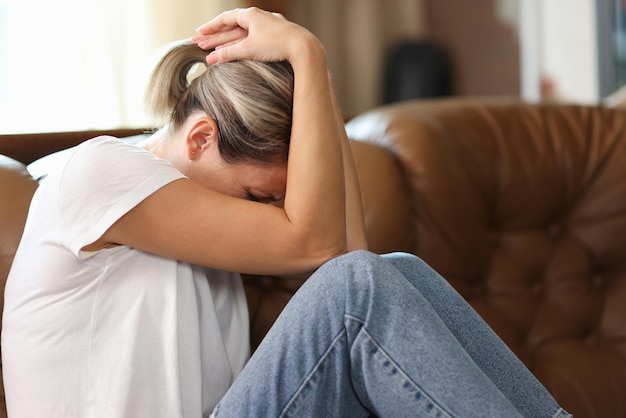 Depressed frustrated woman feels pain sadness and stress because many problems while sitting on couch