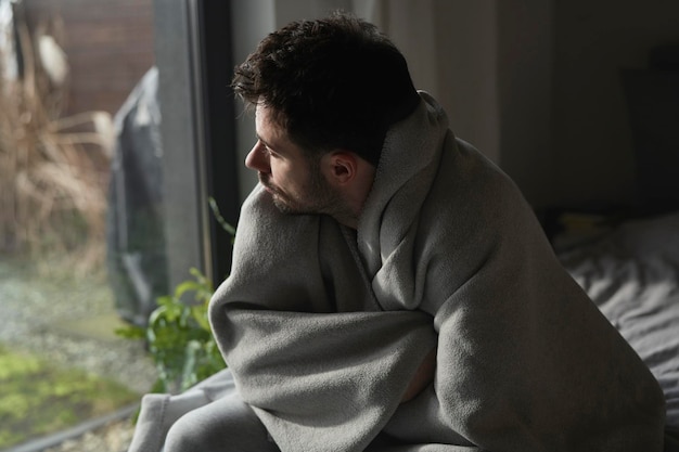 depressed man covered with a blanket