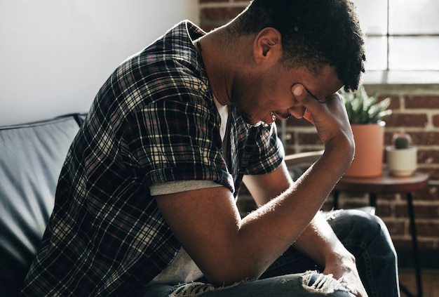 Photo depressed man sitting alone on a couch