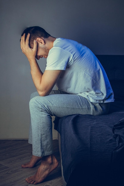 Depressed man sitting on the floor with his head down and leaning against the wall In frustrated feelings The concept of mental disorders Schizophrenia psychosis fear