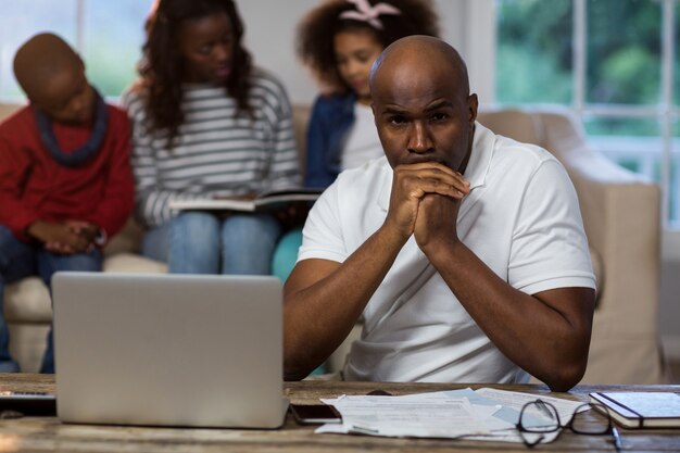 Depressed man with bills and laptop