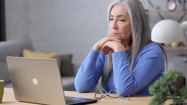 Depressed mature woman recieved bad online news. Burnout syndrome, overworking, depression.