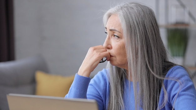 Una donna matura depressa ha ricevuto cattive notizie online. sindrome da burnout, superlavoro, depressione.