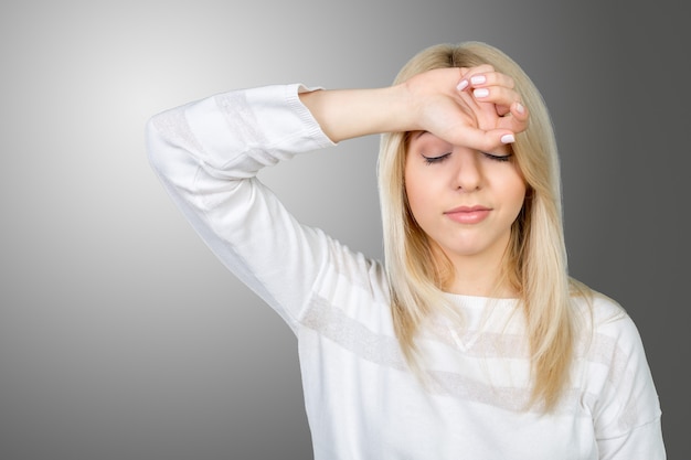 Photo depressed mature woman touching forehead and keeping eyes closed