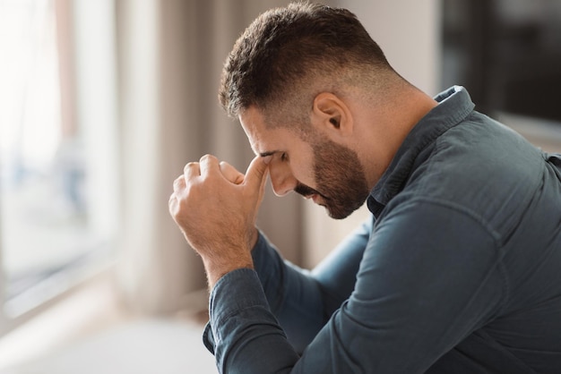 Foto un uomo di mezza età depresso lotta con il dolore seduto a casa