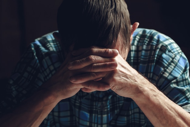 Depressed senior covers his face with his hands. Alzheimer's dis