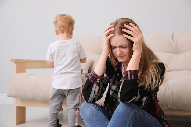 Depressed single mother with child in living room