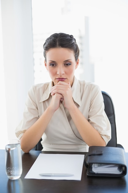 Depressed stylish brunette businesswoman joining her hands