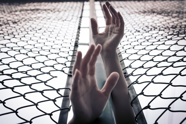 Photo depressed, trouble, help and chance. hopeless women raise hand over chain-link fence