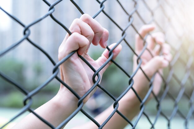 Photo depressed, trouble and solution. women hand on chain-link fence.