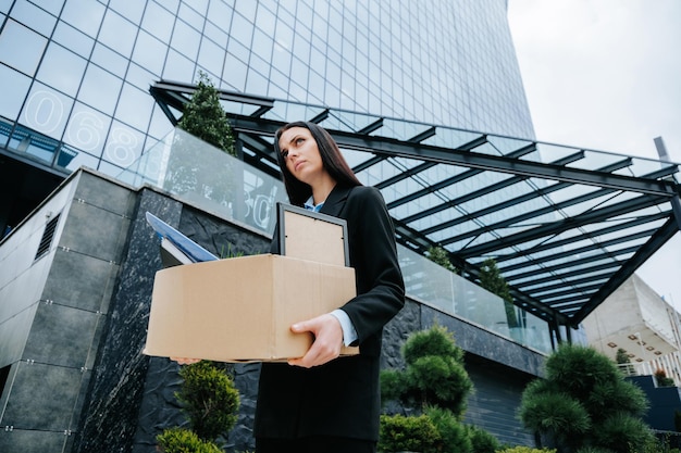 Depressed white collar worker after work loss an unemployed person holds a cardboard box looking wor