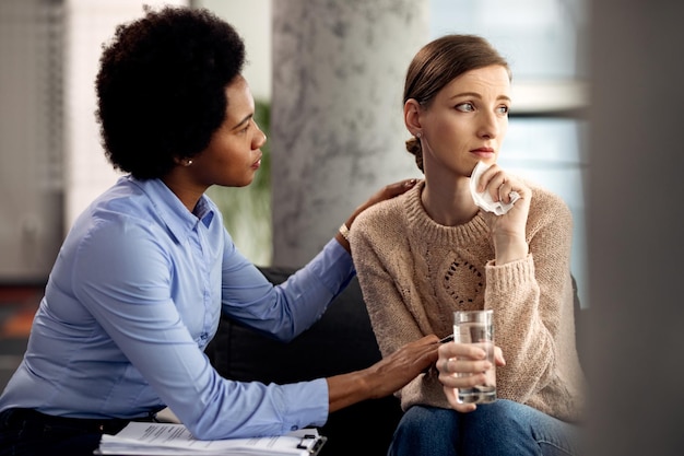 Depressed woman being consoled by her psychotherapist during a session