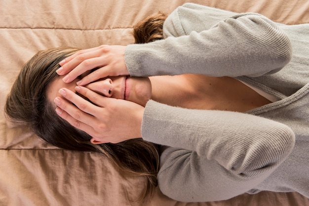 Photo depressed woman laying in bed