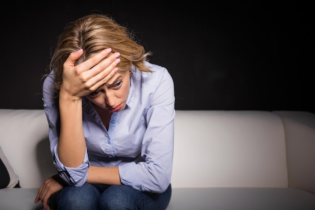 Depressed woman pressing her hand against her forehead