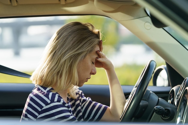 Depressed woman sit in car pondering of problems in family relationship crisis burnout and stress