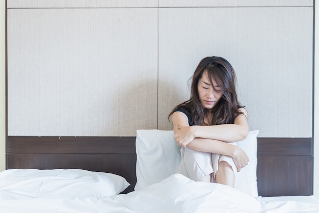 Depressed woman sitting on the bed