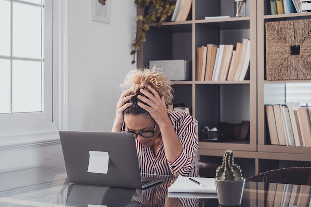 Foto donna depressa seduta davanti al portatile in ufficio