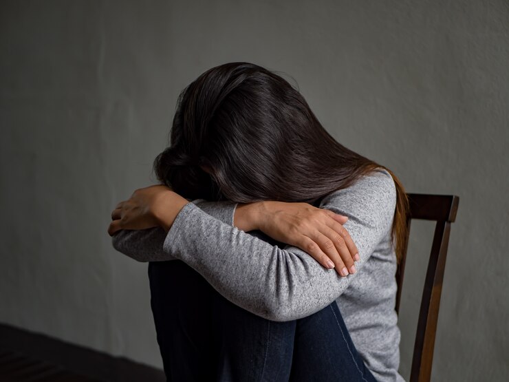 Photo depressed woman sitting on a chair in dark room at home.