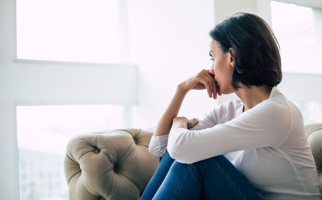 Photo depressed woman with short haircut who is crying while touching her face. girl who is yelling with her eyes closed because of her mental illness.