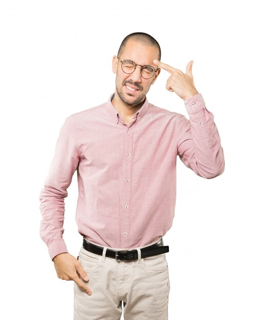 Depressed young man making a suicide gesture