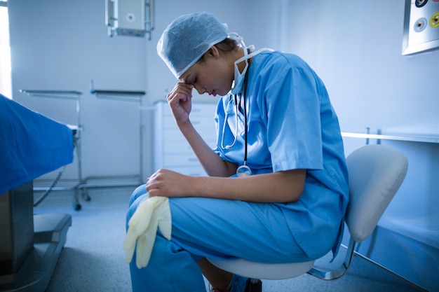 Depressief chirurg zittend op een stoel