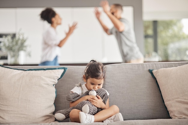 Depressiestress of kindertrauma voor meisje met teddybeer op de bank in de woonkamer en luisterend om te vechten tegen schreeuwen of schreeuwende ouders Burn-out angst of geestelijke gezondheid kind met echtscheiding vader of moeder