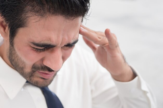 Depressieve Aziatische zakenman; portret van zieke Indiase Aziatische man met depressie die lijdt aan hoofdpijn, duizeligheid, kater, migraine, stress