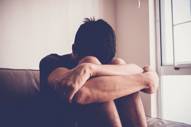 Depressieve en angst man zit alleen thuis, geestelijke gezondheid concept