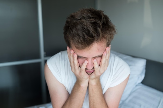 Depressieve man zit in zijn bed en voelt zich slecht