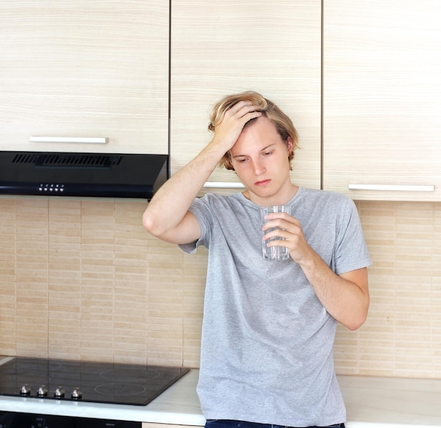 Depressieve tiener die in de keuken staat.