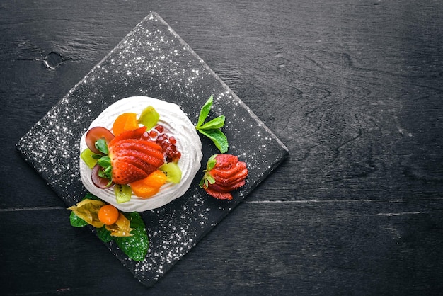 Desart with fresh strawberries and mint. Italian cuisine. Top view. On Wooden background.