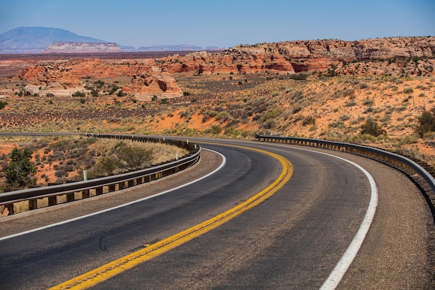 Desert highway at sunset travel concept USA Asphalt road and canyon background