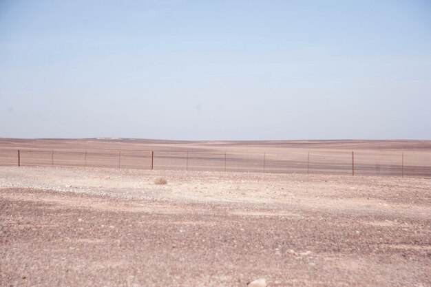 Photo a desert landscape with a fence and a fence in the middle