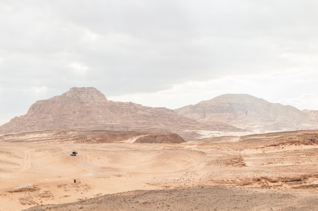 Desert, red mountains, rocks and cloudy sky. Egypt, color canyon.