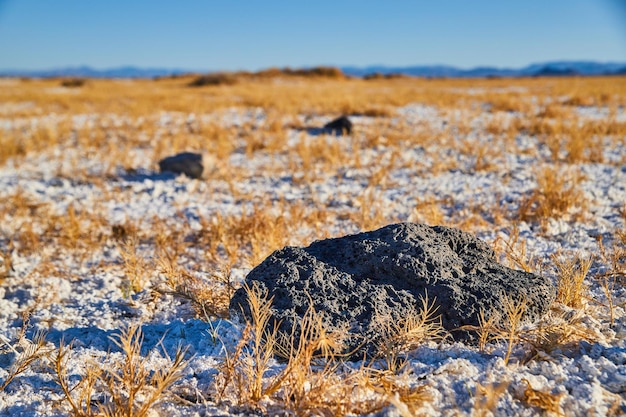 Desert white sand and small black rocks scattered